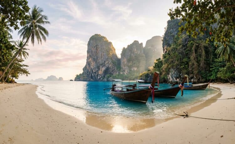 Playa tropical de Tailandia con barcas tradicionales y acantilados